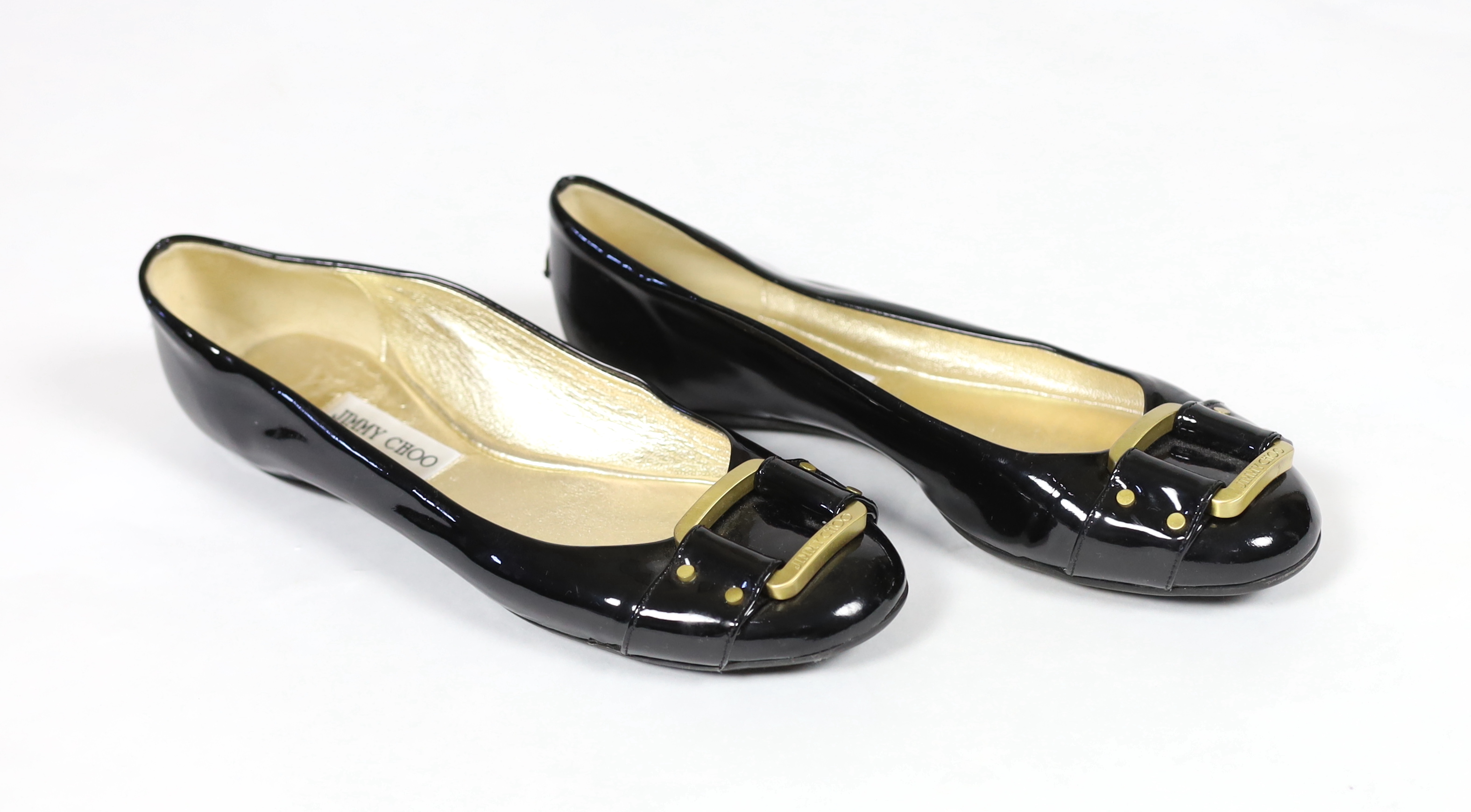 A pair of Jimmy Choo lady's black patent leather pumps with gold buckle, size EU 39